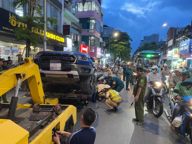 Lực lượng chức năng tiến hành di dời chiếc ô tô khỏi hiện trường. (Ảnh: Vân Đức)